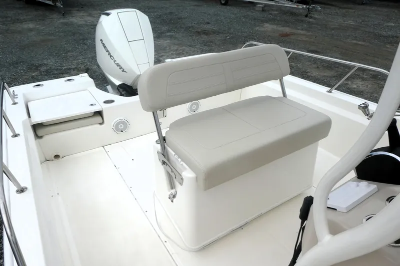 Slide: The Image of 2023 Boston Whaler 210 Montauk boat interior with Mercury engine, featuring seating and storage. - 11