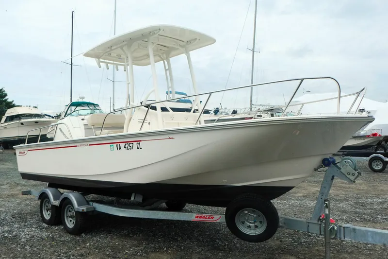 Slide: The Image of 2023 Boston Whaler 210 Montauk boat on trailer, parked in a marina. - 14