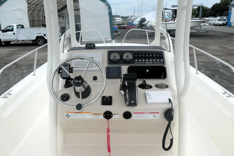 Slide: The Image of 2023 Boston Whaler 210 Montauk boat console with steering wheel and controls. - 7