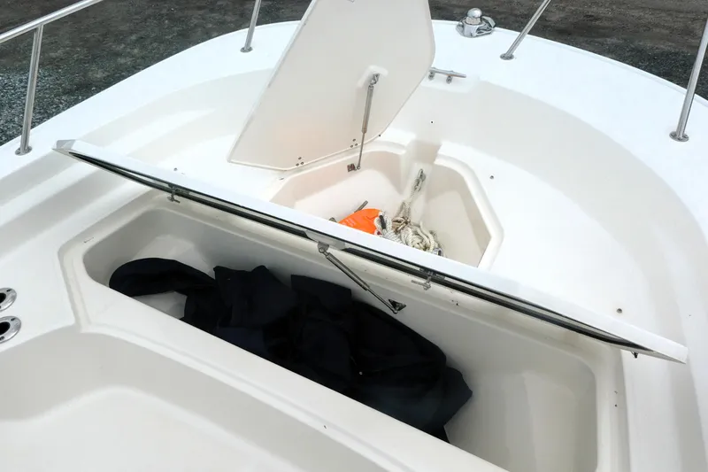 Slide: The Image of 2023 Boston Whaler 210 Montauk boat storage compartments with ropes and gear. - 9