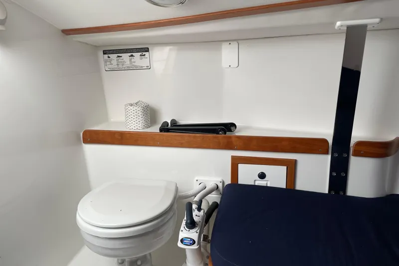Slide: The Image of 2025 Tartan Fantail boat interior with toilet and wooden accents. - 13