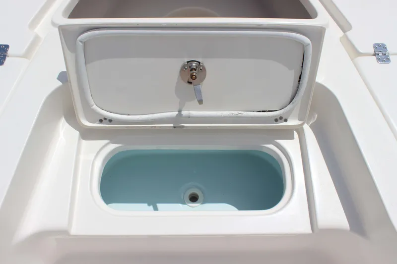 Slide: The Image of Livewell compartment on 2026 Key West 230 Bay Reef boat, featuring a secure latch. - 11