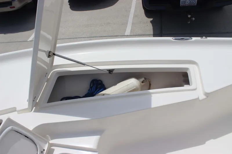 Slide: The Image of Open storage compartment on 2026 Key West 230 Bay Reef boat, containing rope and fender. - 12