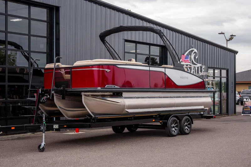 Slide: The Image of 2026 Harris Sunliner 230 pontoon boat on trailer outside dealership. - 15