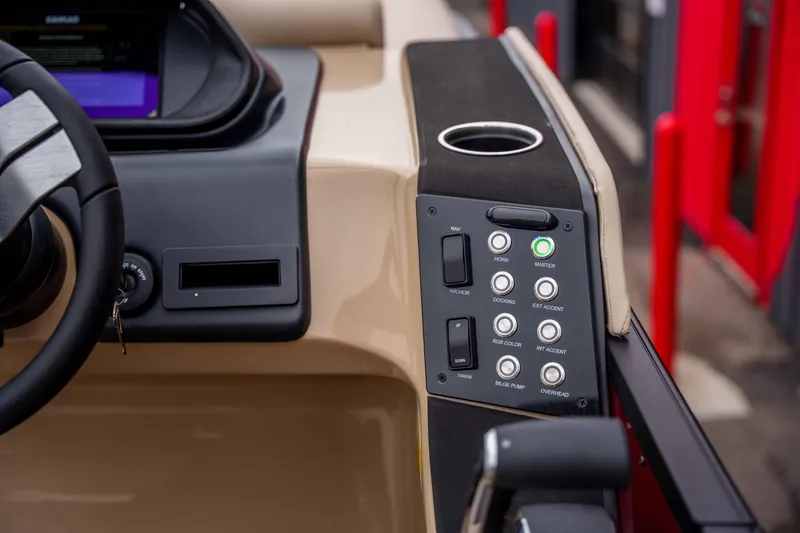 Slide: The Image of Dashboard controls of 2026 Harris Sunliner 230 boat, featuring steering wheel and control panel. - 37