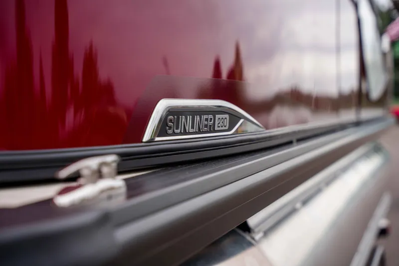 Slide: The Image of 2026 Harris Sunliner 230 emblem on a sleek, reflective red surface. - 41
