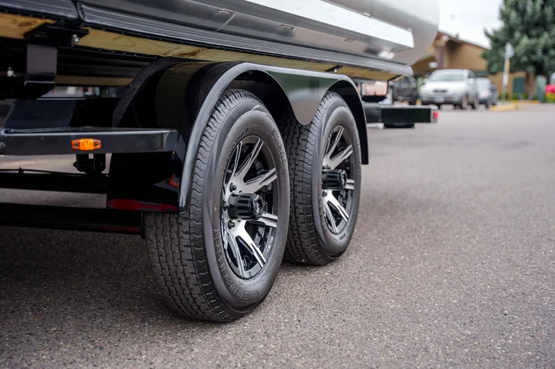 Slide: The Image of Trailer wheels of a 2026 Harris Sunliner 230 boat on pavement. - 42