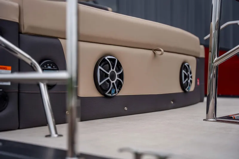 Slide: The Image of 2026 Harris Sunliner 230 boat interior with built-in speakers and beige seating. - 44