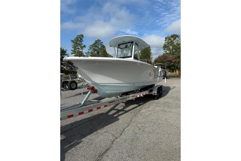 Slide: The Image of 2026 Sea Hunt Ultra 255 SE boat on trailer, parked outdoors under a clear sky. - 13