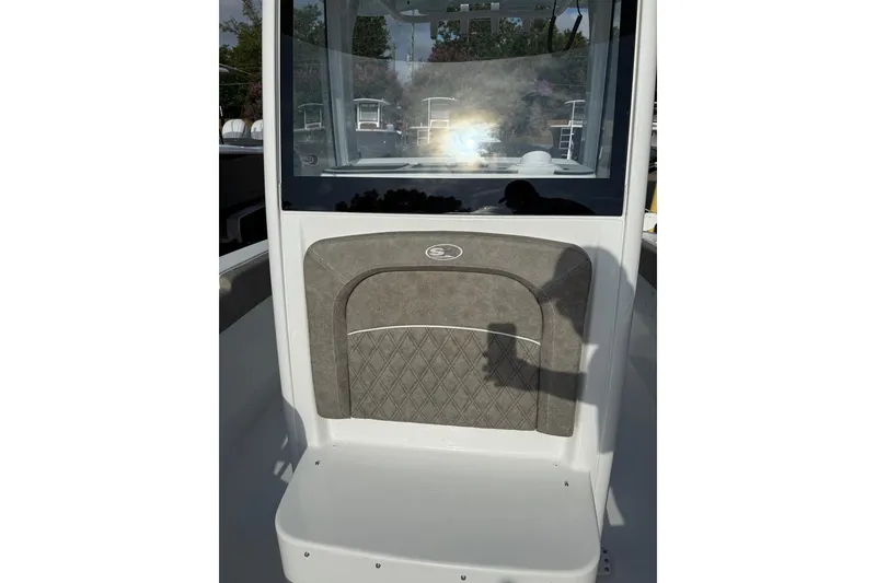 Slide: The Image of 2026 Sea Hunt Ultra 255 SE boat console with cushioned seat and shadow reflection. - 16