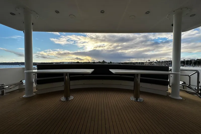 Slide: The Image of Luxury yacht Monte Fino 92 deck with seating, overlooking serene waters and cloudy sky. - 14