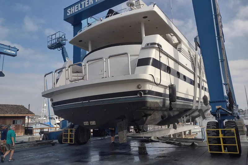 Slide: The Image of Monte Fino 92 yacht from 1996 in a boatyard lift, showcasing its hull and structure. - 3