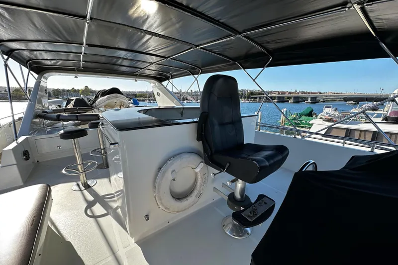 Slide: The Image of Flybridge of 1996 Monte Fino 92 yacht with seating and helm, overlooking marina. - 31