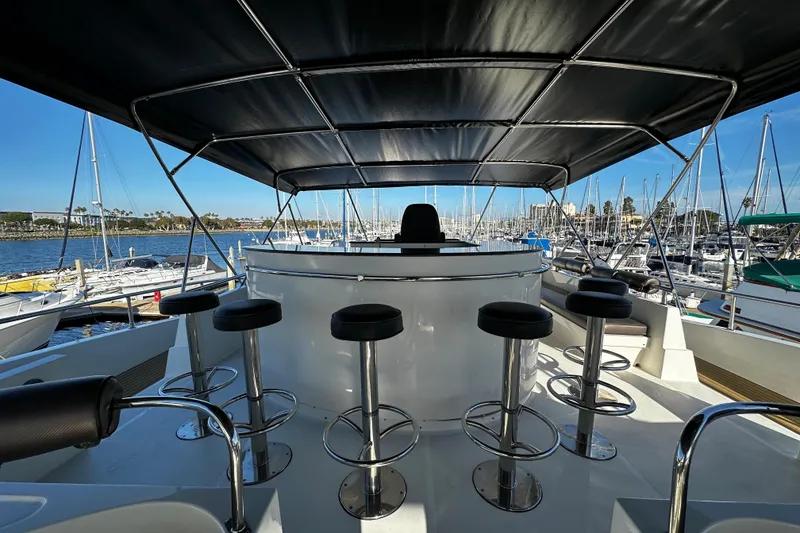 Slide: The Image of Flybridge of 1996 Monte Fino 92 yacht with bar stools and marina view. - 57
