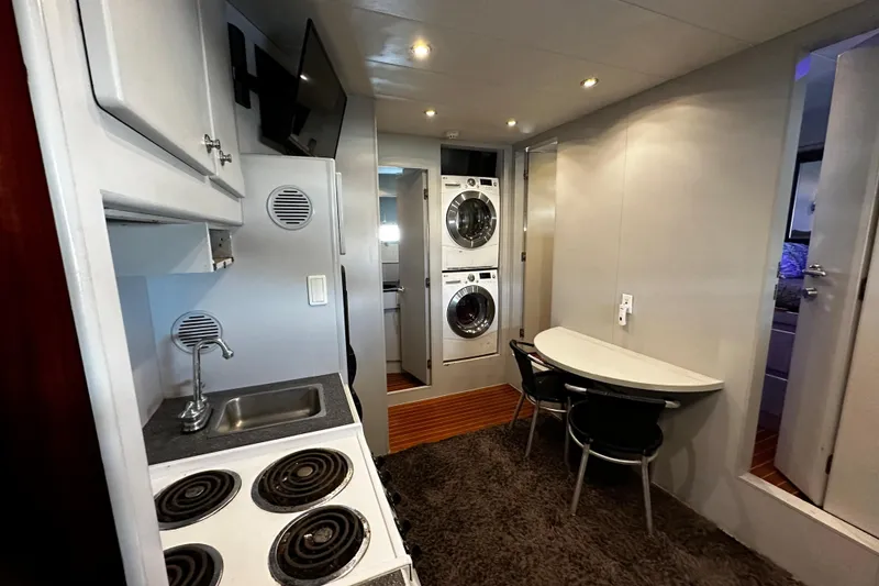 Slide: The Image of Interior of 1996 Monte Fino 92 yacht with kitchenette, dining area, and laundry appliances. - 64