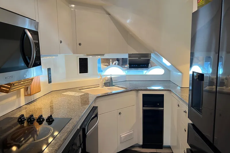 Slide: The Image of Modern kitchen interior on a 1996 Monte Fino 92 yacht, featuring sleek appliances and granite countertops. - 87