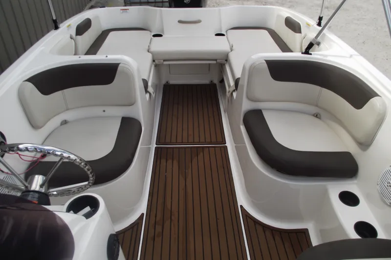 Slide: The Image of 2021 Bayliner Element E18 boat interior with cushioned seating and wood-style flooring. - 11