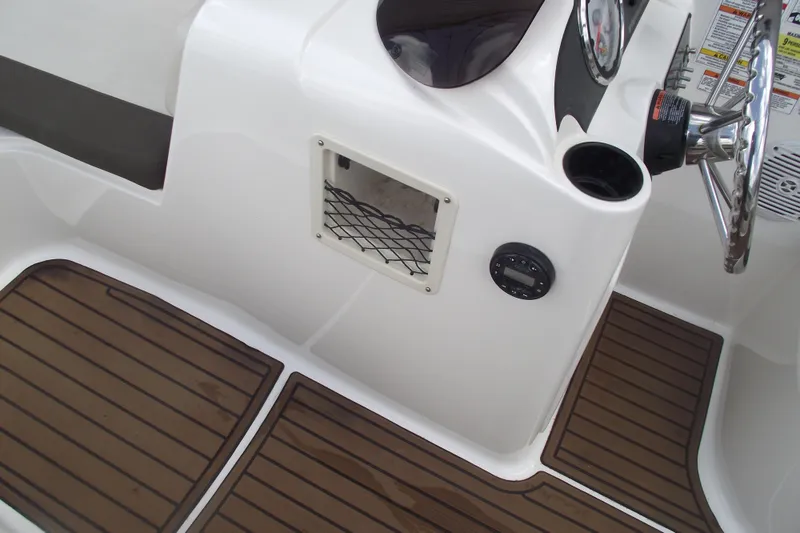 Slide: The Image of 2021 Bayliner Element E18 boat interior with wood-style flooring and steering console. - 12