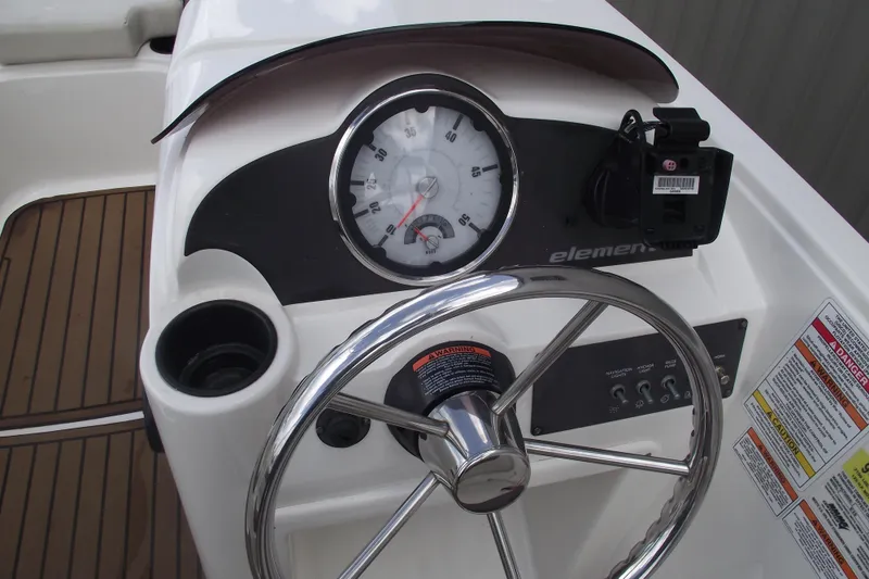 Slide: The Image of 2021 Bayliner Element E18 dashboard with steering wheel and gauges. - 13