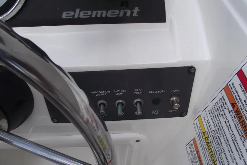 Slide: The Image of Control panel of a 2021 Bayliner Element E18 boat with switches and warnings. - 14