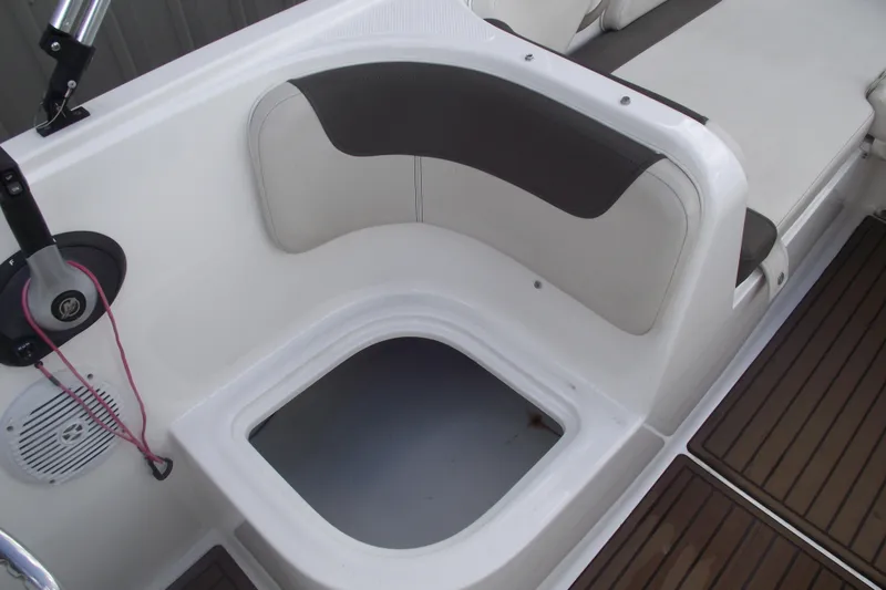 Slide: The Image of 2021 Bayliner Element E18 boat interior with cushioned seating and storage compartment. - 19