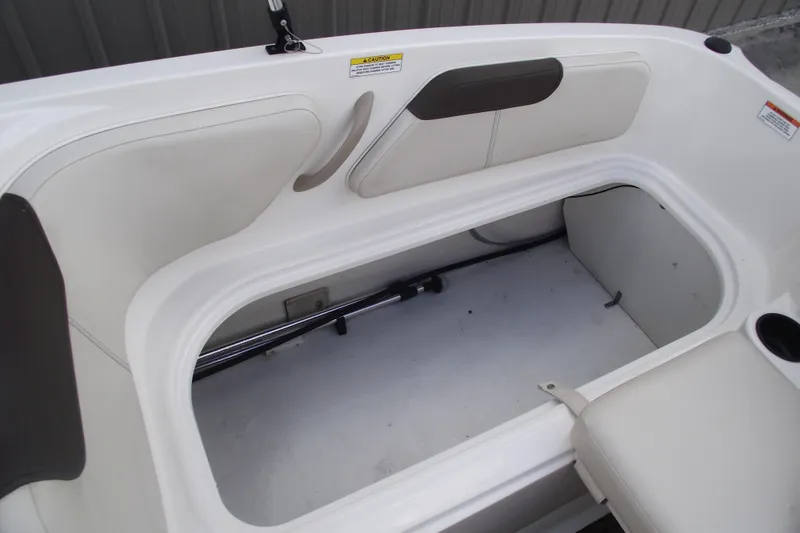 Slide: The Image of 2021 Bayliner Element E18 boat interior storage compartment with cushioned seating. - 21