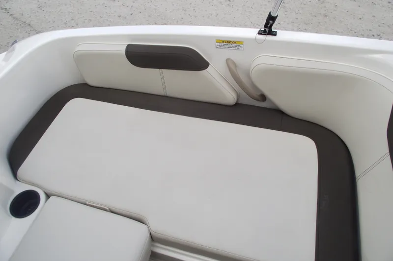 Slide: The Image of 2021 Bayliner Element E18 boat interior seating with white and brown upholstery. - 22