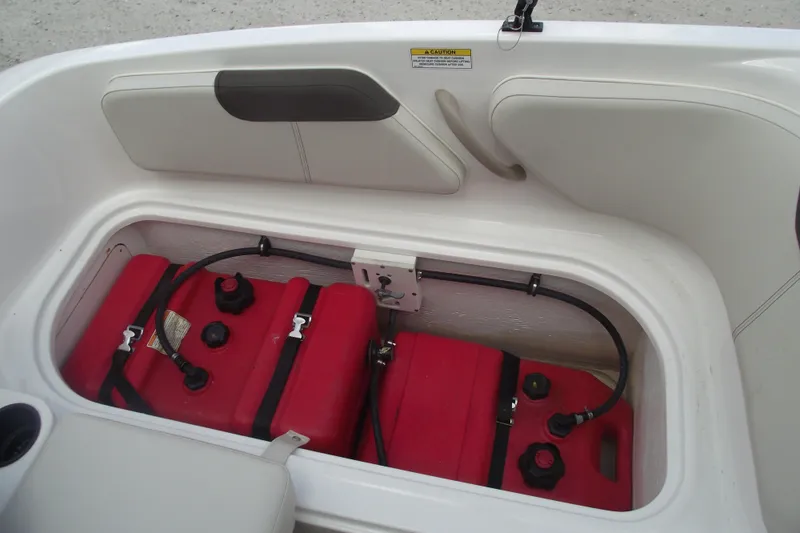 Slide: The Image of 2021 Bayliner Element E18 boat storage compartment with red fuel tanks. - 23