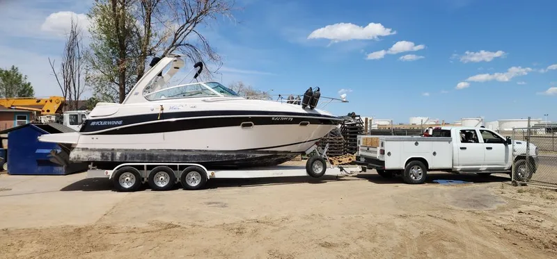 Slide: The Image of 2005 Four Winns 288 Vista boat on trailer with white truck. - 1