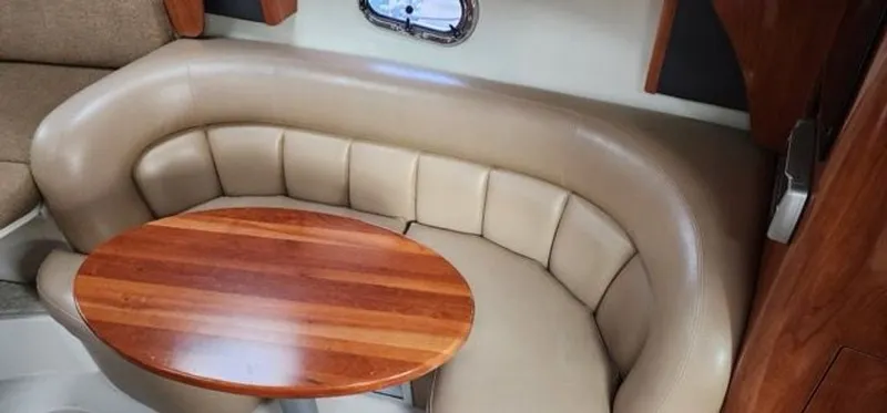 Slide: The Image of Interior of 2005 Four Winns 288 Vista with leather seating and wooden table. - 4