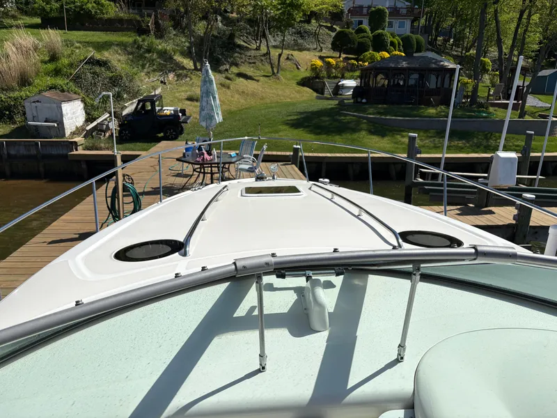 Slide: The Image of A 2006 Sea Ray Sundancer 320 docked at a serene pier with lush surroundings. - 18