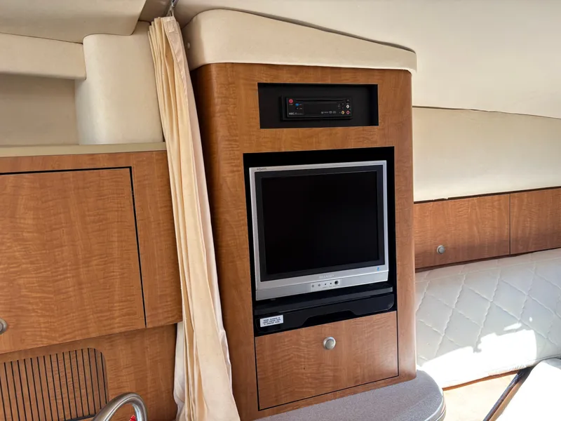 Slide: The Image of Interior of a 2006 Sea Ray Sundancer 320 featuring a built-in TV and wood paneling. - 14