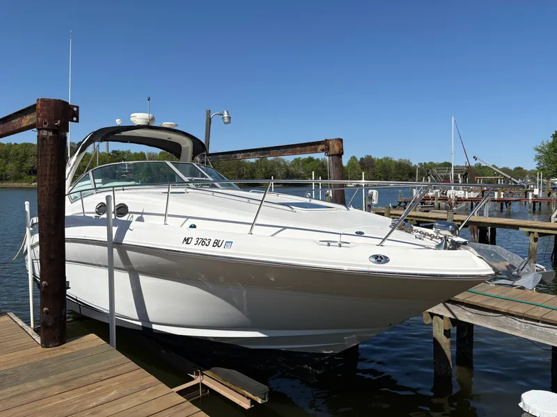 Slide: The Image of A 2006 Sea Ray Sundancer 320 docked at a wooden pier in a calm harbor. - 1