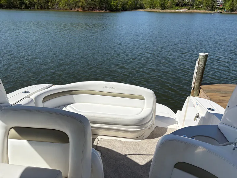 Slide: The Image of The image shows the stern of a Sea Ray Sundancer 320 boat with white seating, overlooking a calm lake. - 17