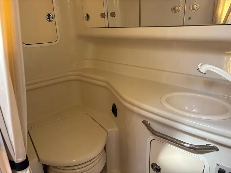 Slide: The Image of The image shows a boat bathroom with a toilet, sink, and storage cabinets. - 16