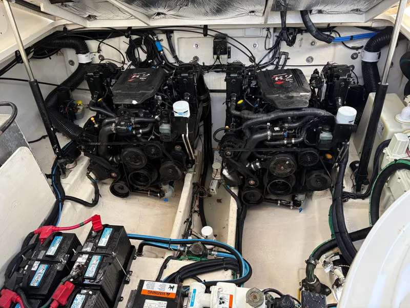 Slide: The Image of The engine room of a 2006 Sea Ray Sundancer 320 features two large engines and batteries. - 19