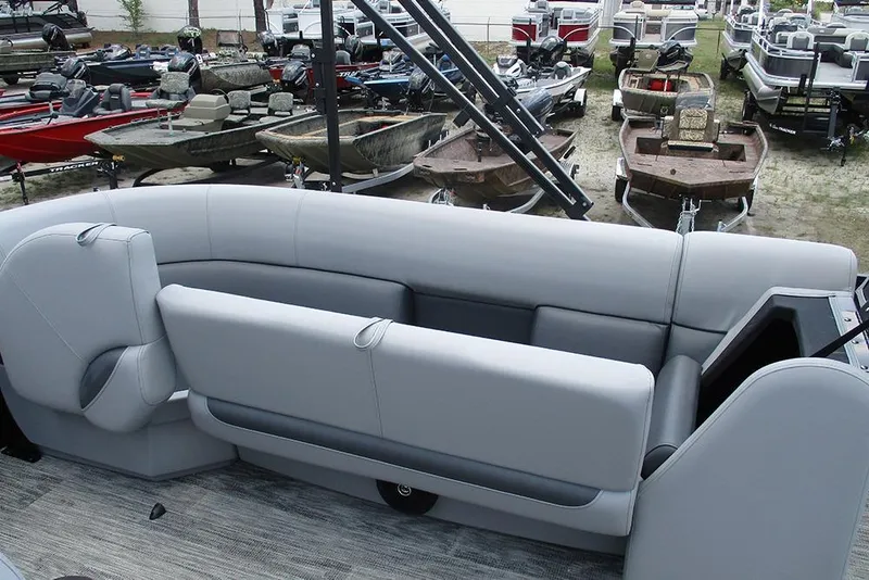 Slide: The Image of 2026 Bentley Pontoons Bolt 203 interior with gray seating, surrounded by various boats. - 18