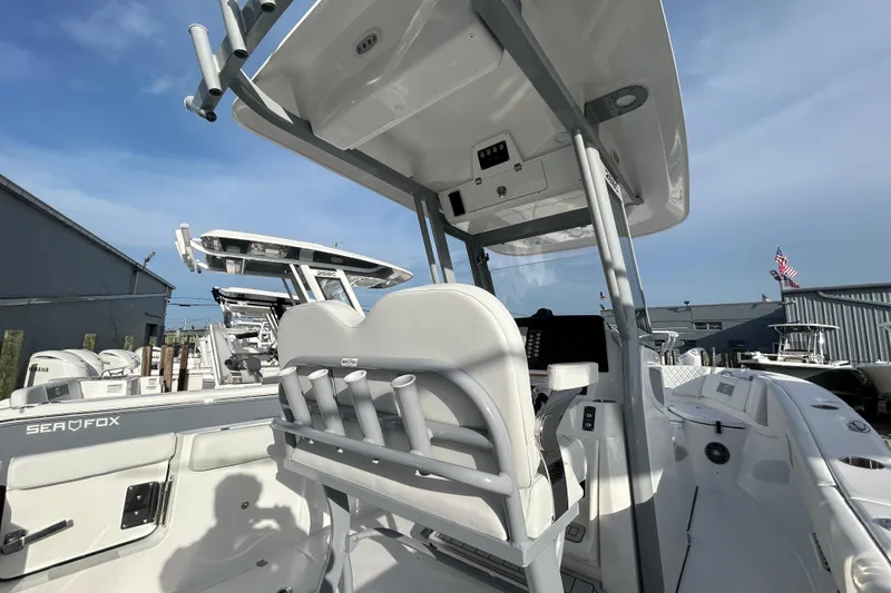 Slide: The Image of 2026 Sea Fox 268 Commander boat interior with helm station and seating, under clear blue sky. - 2