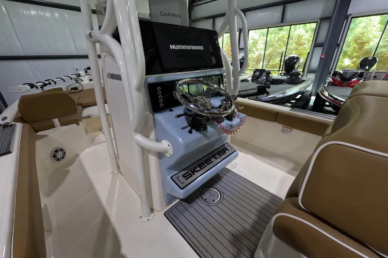Slide: The Image of 2024 Skeeter SX2550 Family boat interior with steering console and seating in showroom. - 12