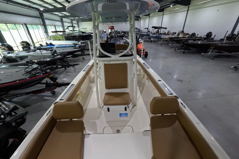 Slide: The Image of 2024 Skeeter SX2550 Family boat interior in showroom, featuring seating and console. - 7