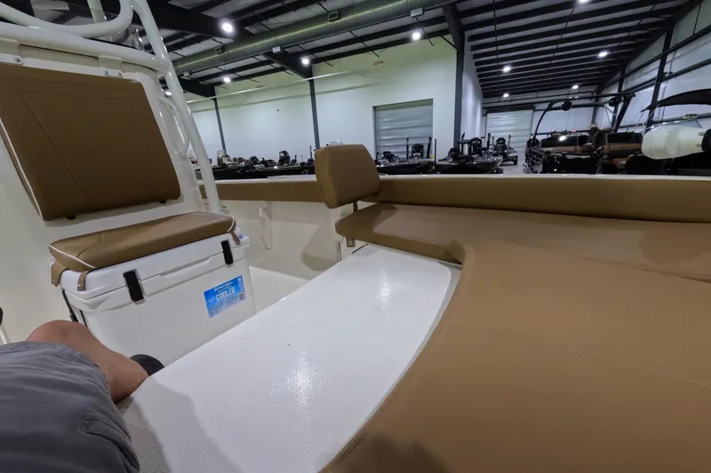 Slide: The Image of 2024 Skeeter SX2550 Family boat interior with tan seating and cooler in showroom. - 8