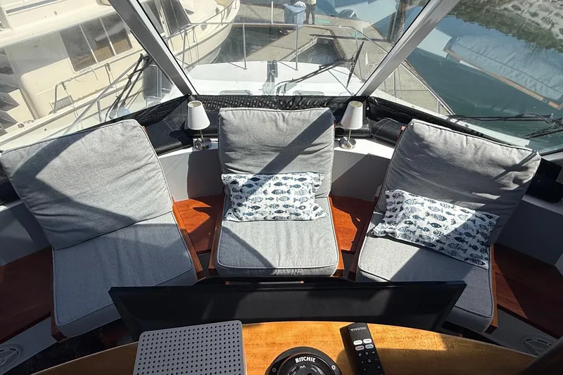 Slide: The Image of Interior view of 2004 TLD Custom Power Cat with three cushioned seats and nautical-themed pillows. - 16