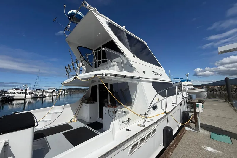 Slide: The Image of 2004 TLD Custom Power Cat docked at marina under clear blue sky. - 2