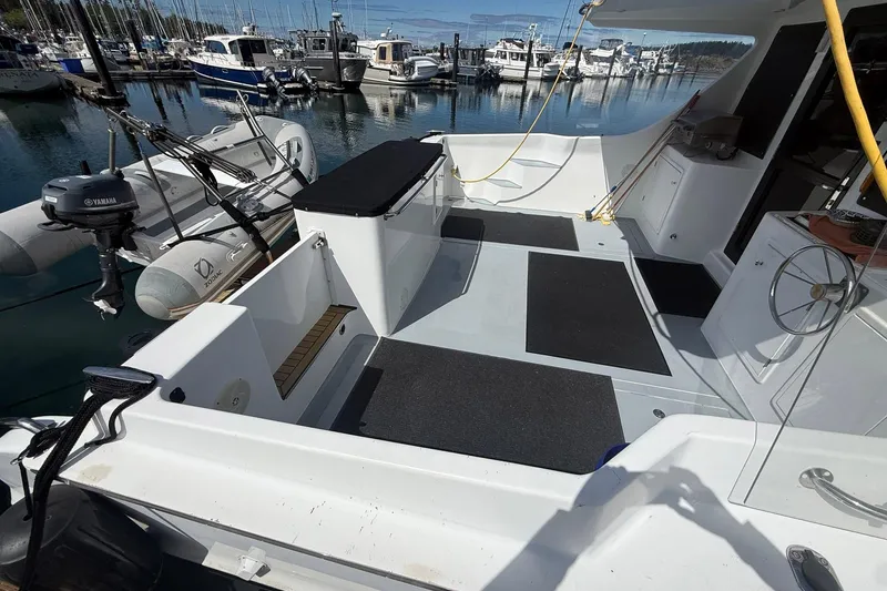 Slide: The Image of 2004 TLD Custom Power Cat boat interior with docked inflatable dinghy and marina view. - 4