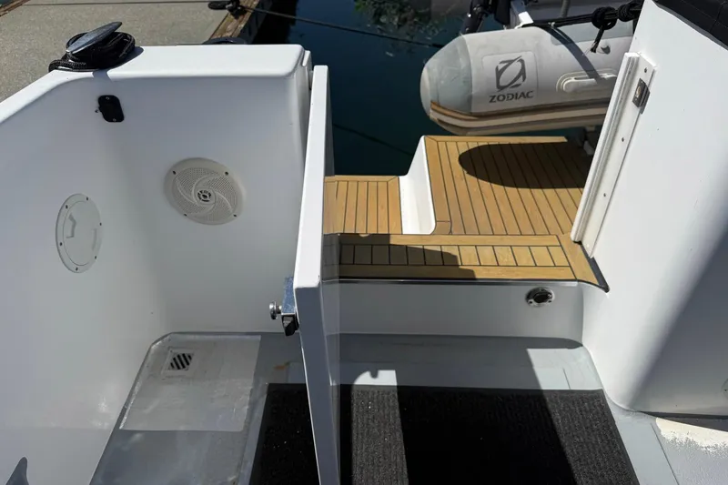 Slide: The Image of 2004 TLD Custom Power Cat boat deck with wood finish and Zodiac inflatable. - 6