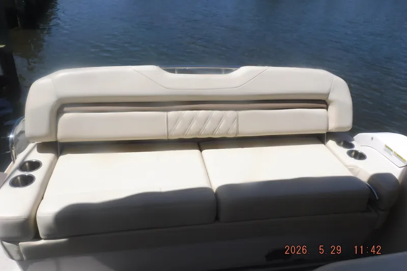 Slide: The Image of 2020 Regal 33 XO boat with beige seating and cup holders, docked by the water. - 21