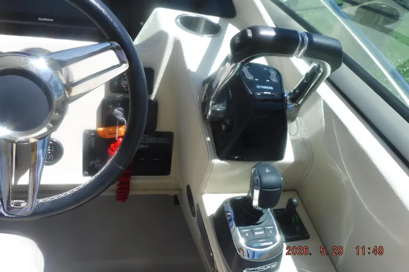 Slide: The Image of Control panel of a 2020 Regal 33 XO boat with steering wheel and throttle controls. - 28