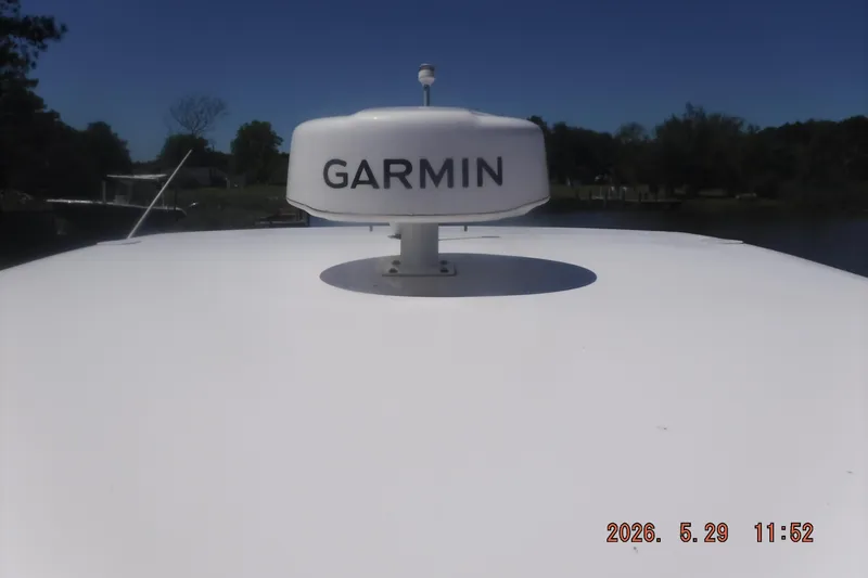 Slide: The Image of Garmin radar on 2020 Regal 33 XO boat under clear blue sky. - 32