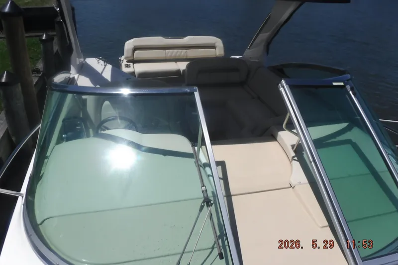 Slide: The Image of 2020 Regal 33 XO boat with open cockpit and seating, docked by the water. - 33