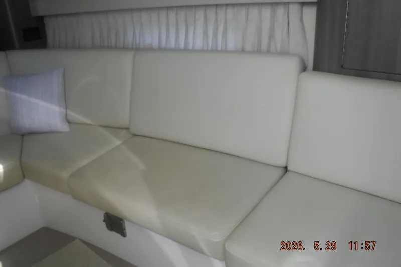 Slide: The Image of Interior seating of 2020 Regal 33 XO boat with white upholstery and a cushion. - 37
